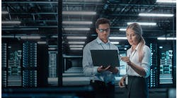 man-and-woman-reviewing-information-on-laptop-in-a-data-center