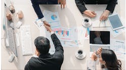 four-business-people-making-agreement-over-table-with-papers-featuring-data-charts