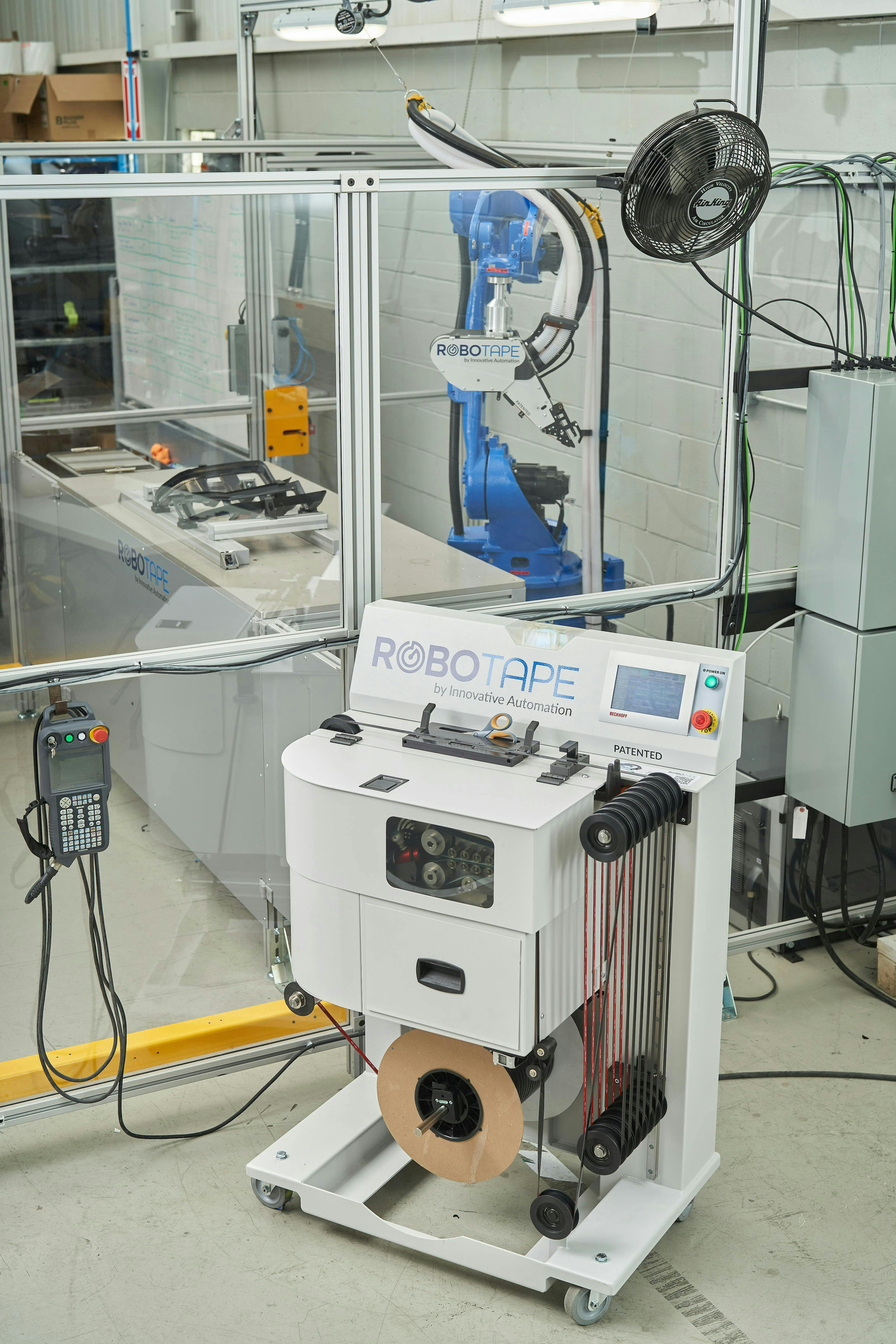Figure 8: The RoboTape’s remote feeding system allows operators to change spools without entering the robot cell, eliminating potential hazards. Figure 8: The RoboTape’s remote feeding system allows operators to change spools without entering the robot cell, eliminating potential hazards.