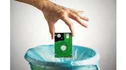 Person's hand throws a computer hard disk into the trash bin