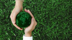 Two hands holding green earth together on nature background for the Sustainable Development Goals