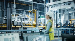 Car Factory: Female Automotive Engineer Wearing Hard Hat, Standing, Using Laptop