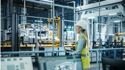 Car Factory: Female Automotive Engineer Wearing Hard Hat, Standing, Using Laptop